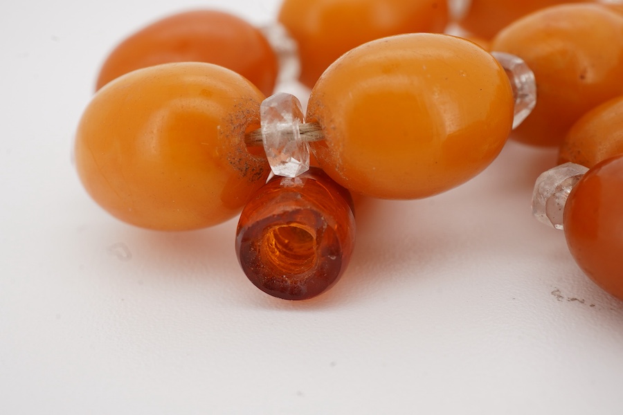 A single strand graduated oval amber bead necklace, with paste spacers, 44cm, gross weight 26 grams, one clasp missing.